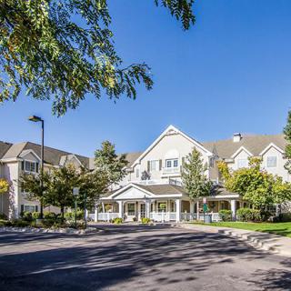 A sunny day view of a residential building surrounded by trees.
