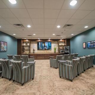 A modern conference room with arranged seating and a large television.