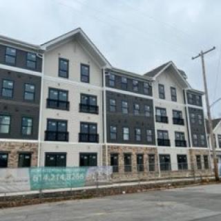 A newly constructed residential apartment building under a cloudy sky.