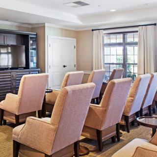 A cozy conference room with comfortable chairs facing a television, ready for a meeting.