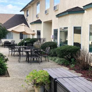Outdoor patio area with tables and chairs near a building.