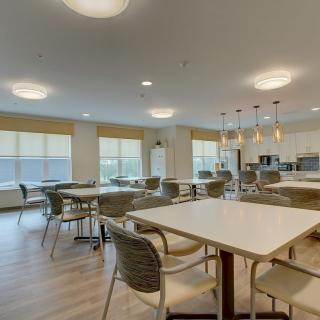 A modern dining area with wooden flooring and ample natural light.