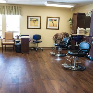 A cozy salon interior featuring barber chairs and an office desk.