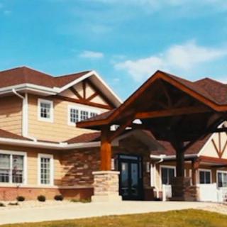 A large residential house with a prominent wooden entrance and a well-maintained lawn.