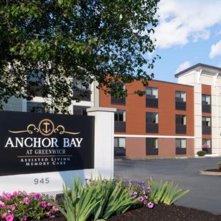 A modern building with a sign for Anchor Bay surrounded by landscaping.