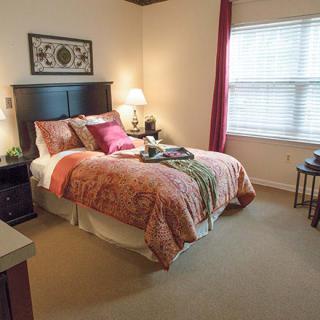 A cozy bedroom with a neatly made bed and soft lighting.