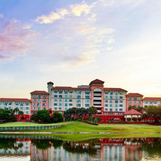 A picturesque view of a hotel by the water during sunset.
