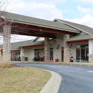 A welcoming entrance to a modern facility with a carport and landscaped surroundings.