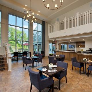A modern restaurant dining area featuring elegant furnishings and large windows.