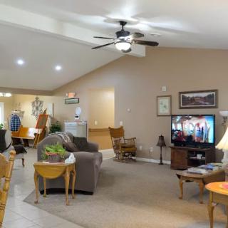 A cozy living room with comfortable seating, a TV, and various home decorations.