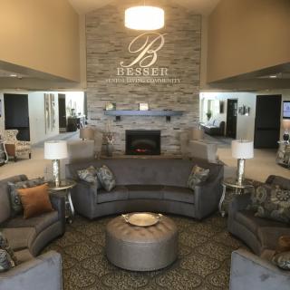 A luxurious hotel lobby featuring a cozy seating area with a central fireplace and elegant decor.
