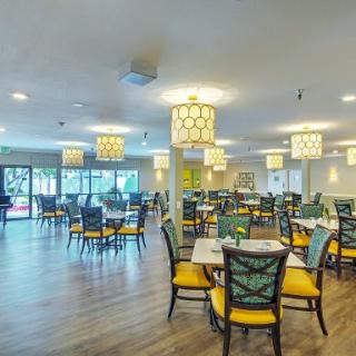 A well-lit dining area with neatly arranged tables and chairs.