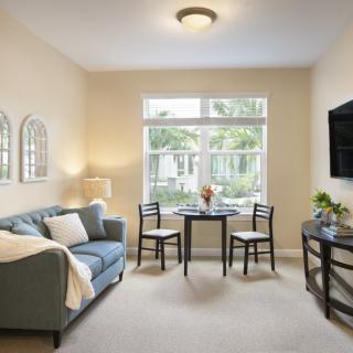 A cozy living room with a sofa, chairs, and table by the window.