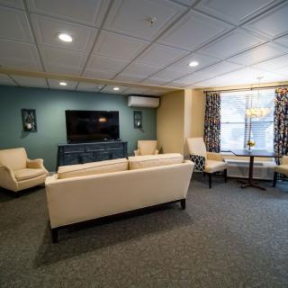 A cozy living room with modern furniture and a large television.