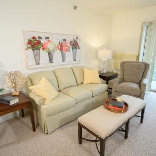 A cozy living room setup featuring a light-colored sofa, an armchair, and a decorative coffee table.