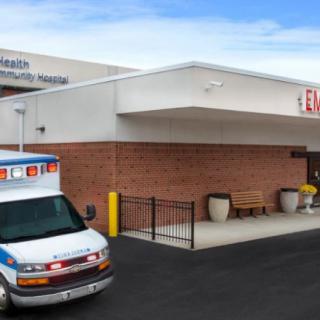 An ambulance parked outside an emergency room entrance at a hospital.