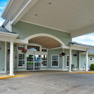 A building entrance with a covered walkway and decorative columns.