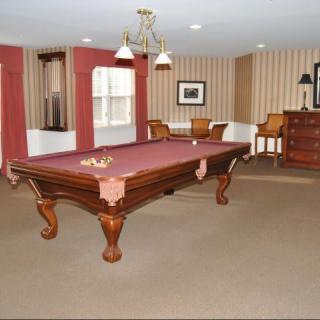 A well-furnished game room featuring a classic pool table and elegant decor.