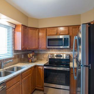 A modern kitchen with wooden cabinets and stainless steel appliances.