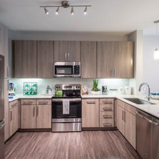 A modern kitchen with sleek appliances and wooden cabinetry.