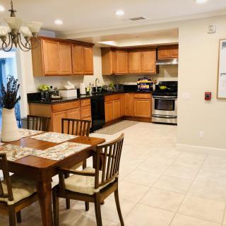 A cozy kitchen with wooden cabinets and a dining table set for four.