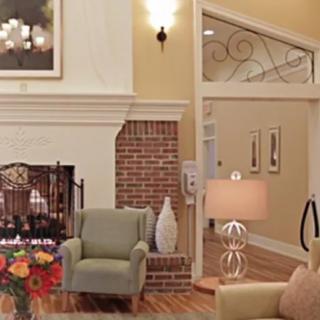 A cozy living room with a fireplace, armchair, and decorative elements.
