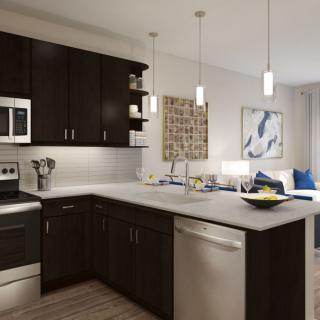 A modern kitchen featuring dark cabinets and sleek appliances, illuminated by pendant lights.