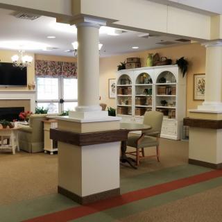 A comfortable living room area with seating, shelves, and a television.