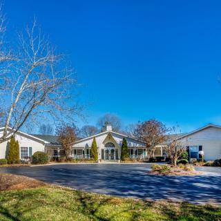A spacious house with a landscaped driveway under a clear blue sky.