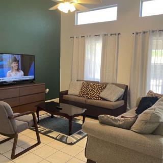 A cozy living room with modern furniture and a television.