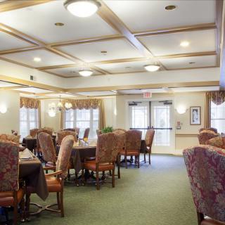 A well-lit dining room featuring elegant furniture and multiple tables set for meals.