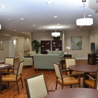 A spacious lounge area with comfortable seating and wooden floors.