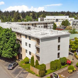 A modern residential apartment building surrounded by lush greenery.