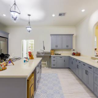 A modern kitchen with gray cabinets and sleek countertops.