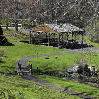 A serene park scene featuring a gazebo, a winding pathway, and lush greenery.