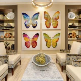 A modern living room featuring colorful butterfly artwork and elegant decor.