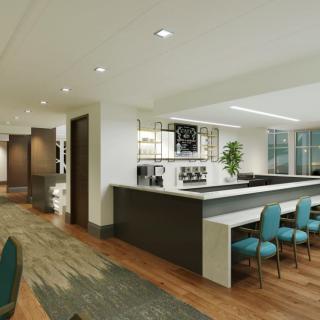 A modern office interior with a conference area and kitchen space.