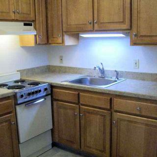 A compact kitchen with wooden cabinets and modern appliances.