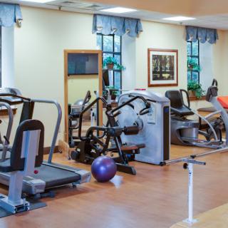 A well-equipped gym featuring various exercise machines and a workout space.