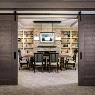 A modern dining room featuring sliding doors, built-in bookshelves, and elegant lighting.