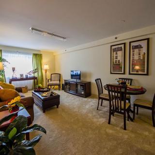 Cozy living room with a dining area, featuring comfortable furniture and warm lighting.