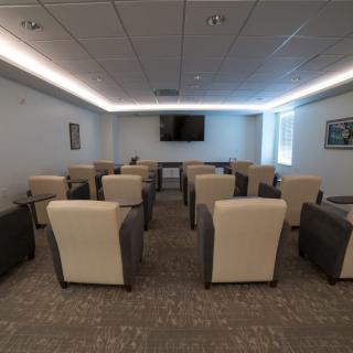 An indoor conference room with arranged seating and a television for presentations.