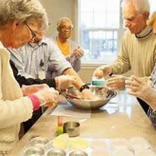 A group of seniors engaged in a cooking activity together.