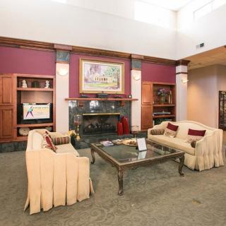 A cozy living room with two sofas, a coffee table, and a fireplace adorned with artwork.