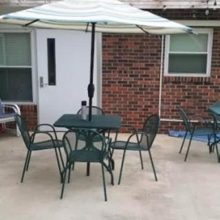 Outdoor patio area with table, chairs, and an umbrella.