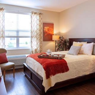 A cozy and inviting bedroom featuring warm colors and natural light.