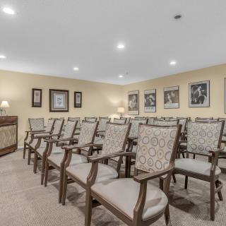An empty conference room with neatly arranged chairs and decorative paintings on the walls.