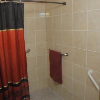 A tiled shower area with a colorful curtain and towel.