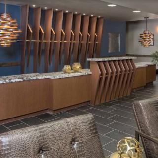 A modern reception area featuring sleek wooden furniture and contemporary lighting fixtures.