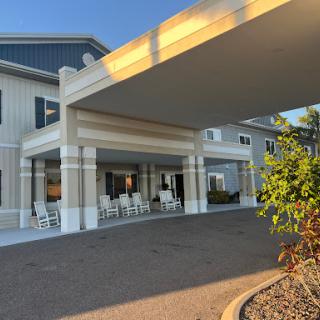 A welcoming residential building with a covered entrance and comfortable seating.